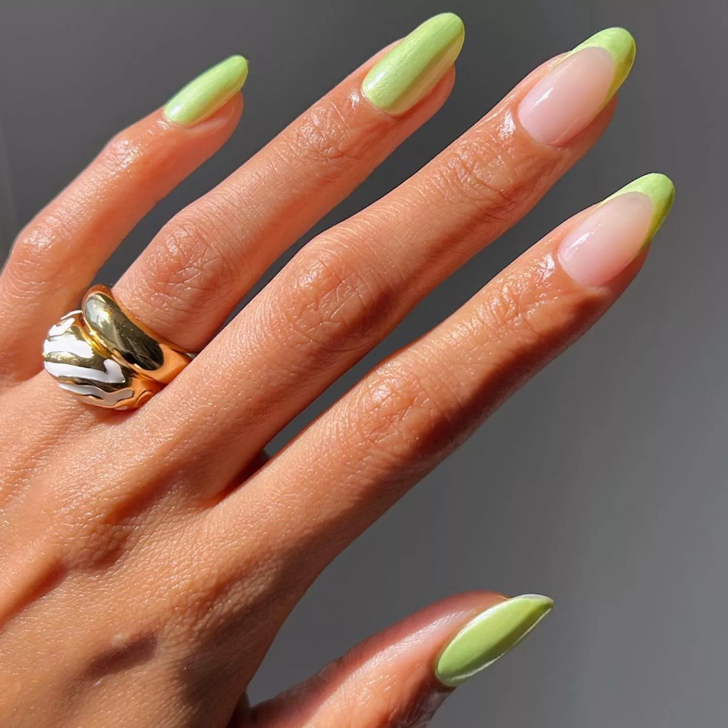 Bright green manicure with two French tip accent nails