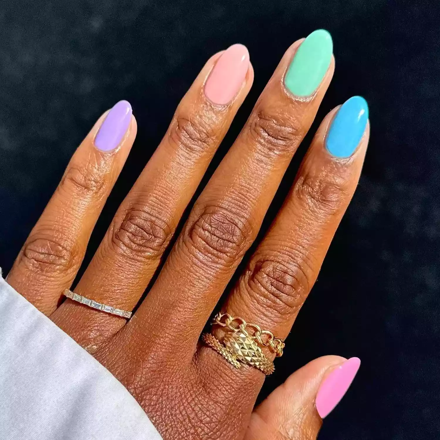 woman's hand with different pastel shade on each nail