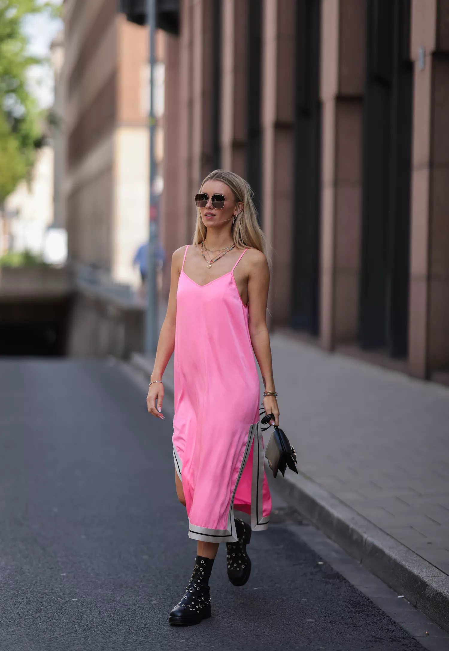 Scarlett Gartmann-Reus seen wearing a black sunglasses, a pink midi dress from Palm Angels, a black leather handbag from Palm Angels and black boots with golden studs